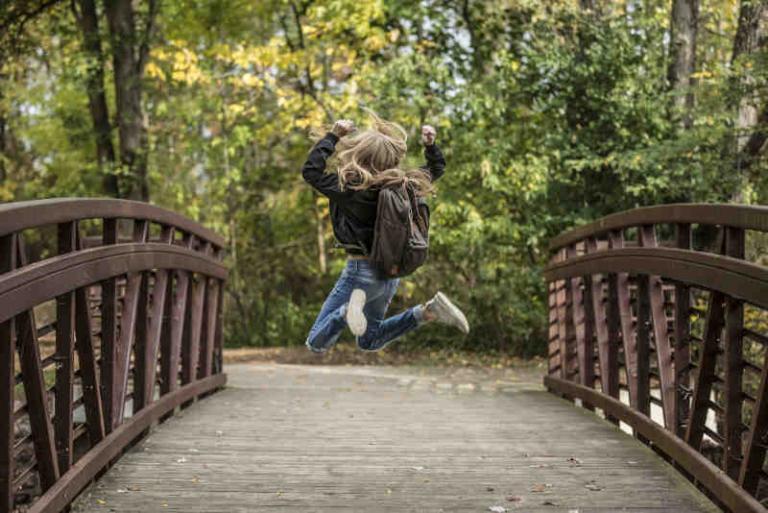 Kind springt freudig auf Brücke